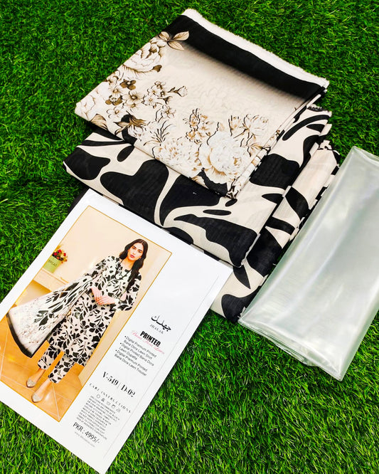 Black and white patterned fabric, white clutch bag, and magazine on grass